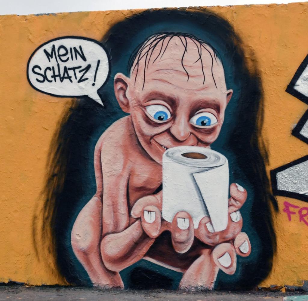 A-man-passes-by-a-graffiti-on-a-wall-at-Mauerpark-in-Berlin.jpg